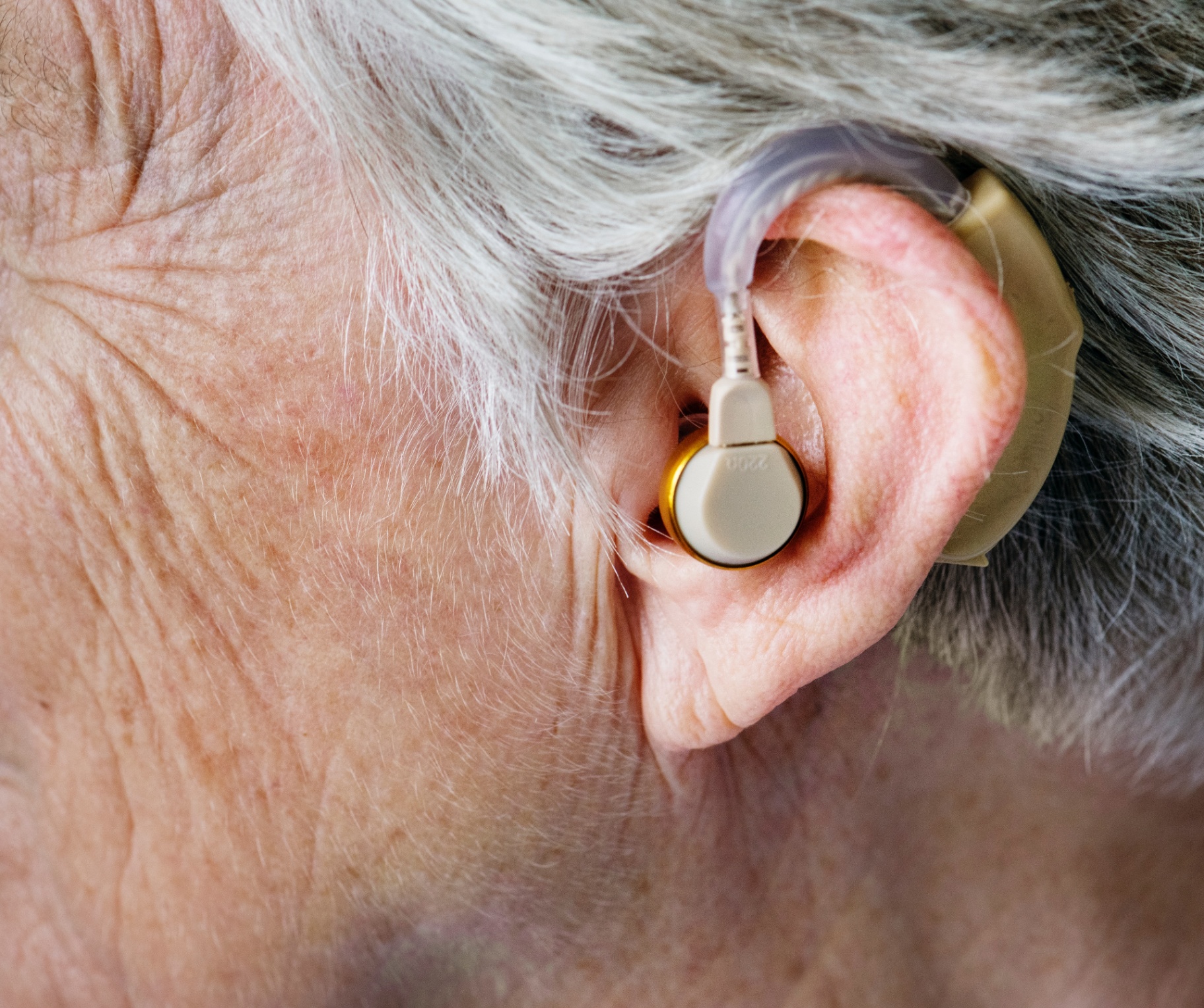 Person frustrated with outdated hearing aids