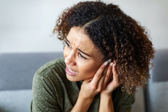 Woman experiencing discomfort from blocked earwax
